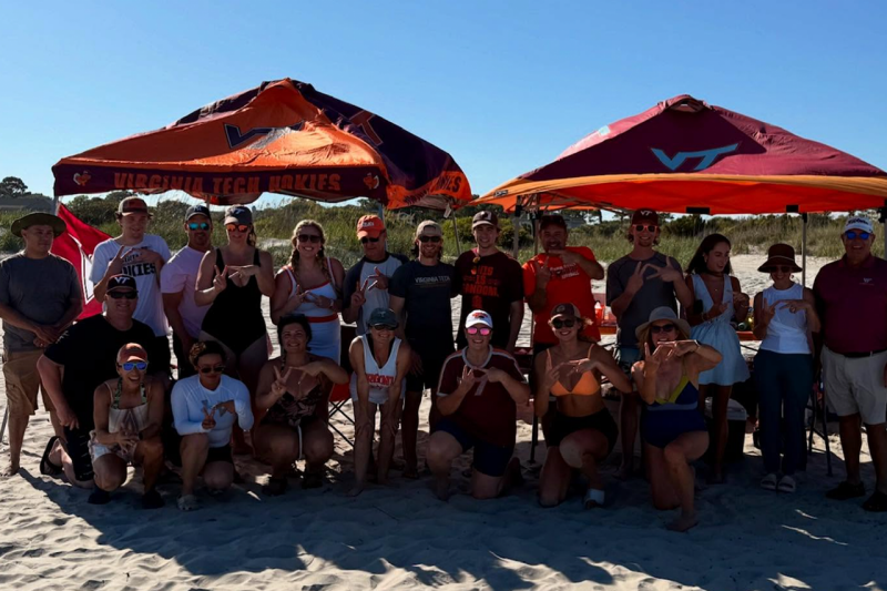 Charleston Hokies pose under tents at the beach