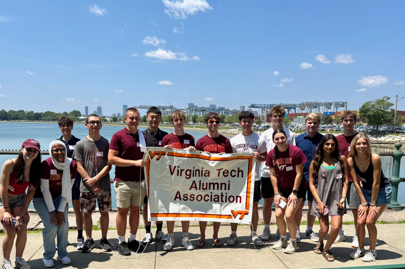 New England Alumni Chapter volunteers pose with an alumni association banner