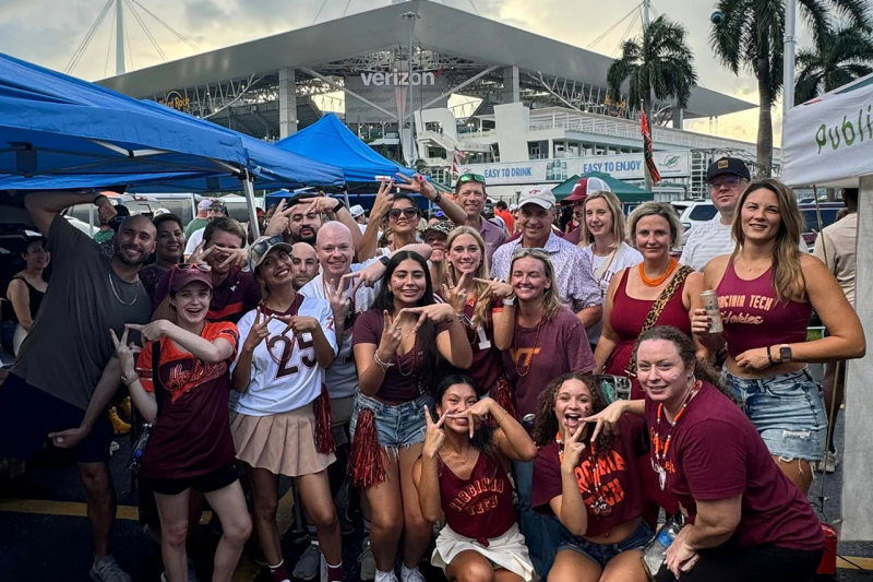 A large group of people from the South Florida Hokies pose outside